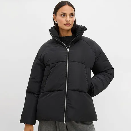 Zwarte gewatteerde jas met hoge kraag en ritssluiting.