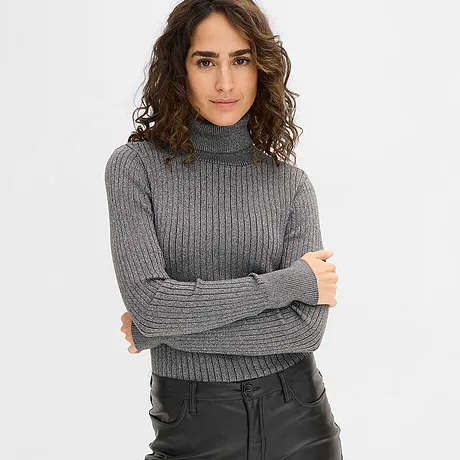 Grijze coltrui gecombineerd met zwarte imitatieleren broek.