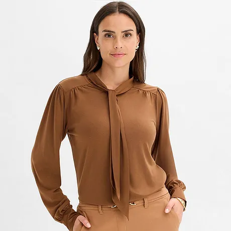 Bruin shirt met striklint bij de kraag en lange mouwen.