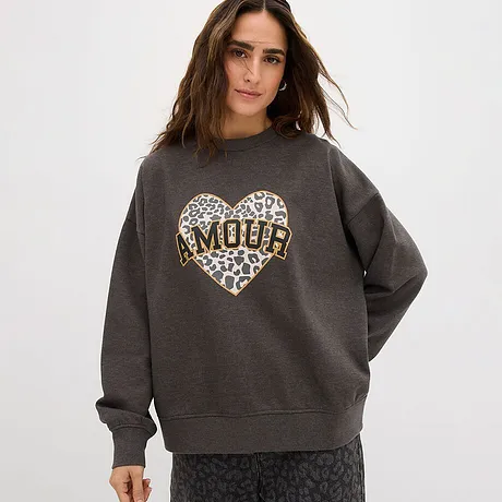 Grijze sweater met groot hart met luipaardprint en tekst 'AMOUR'.