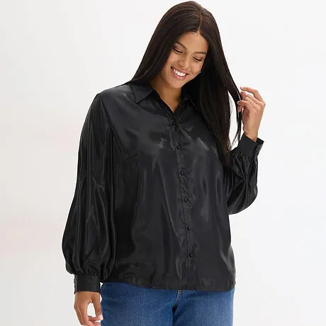 Zwarte blouse met kraag en knopen, gecombineerd met blauwe jeans.