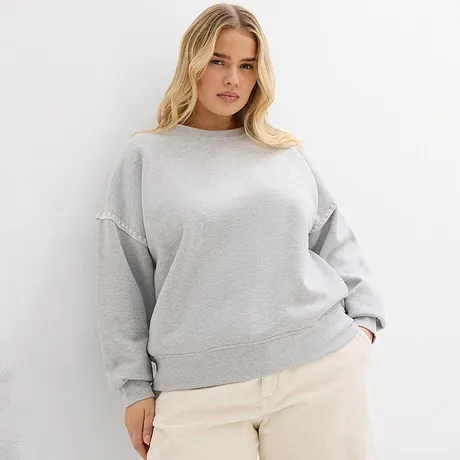 Grijs sweatshirt gecombineerd met lichte broek.