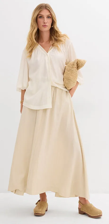 Luftiges, cremefarbenes Sommeroutfit mit weiter Bluse und langem Rock.