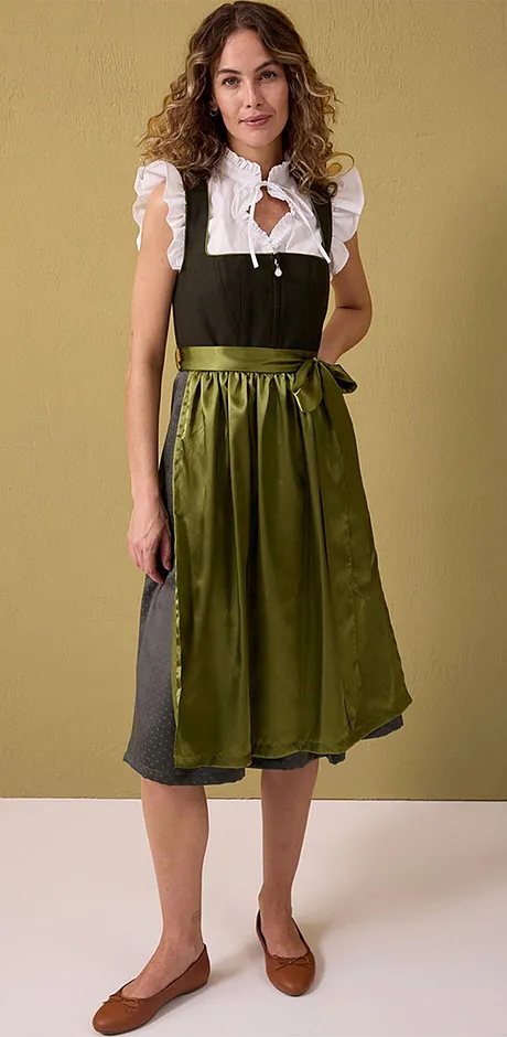 Traditionele klederdracht met witte blouse, donker groene en lange olijfgroene rok met bies.
