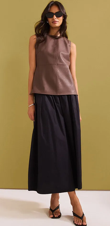 Elegante outfit met een bruine top en een lange zwarte rok.