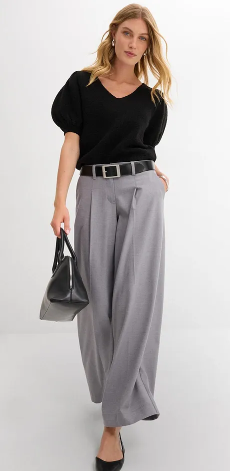 Elegante look met een zwarte blouse, wijde grijze broek en een stijlvolle riem.