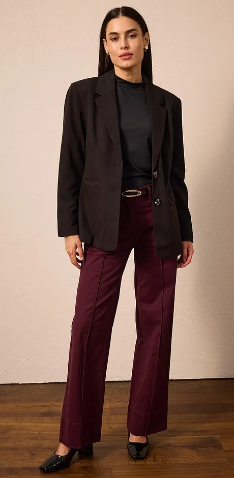Zwarte blazer, donkere coltrui en een bordeauxrode broek.