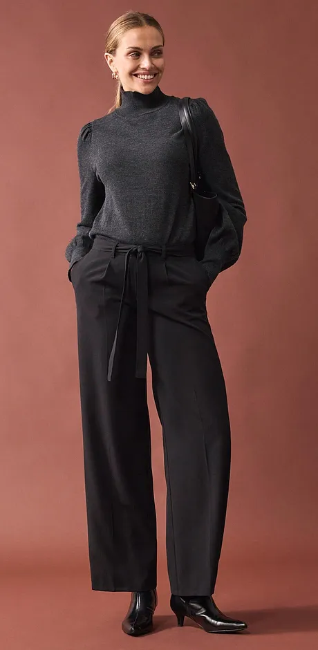 Grijze coltrui gecombineerd met wijde broek.