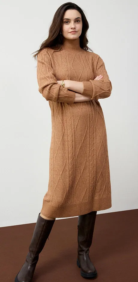 Warme gebreide jurk in camel, gecombineerd met bruine leren laarsjes - met een elegante herfstlook.