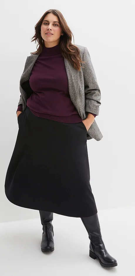 Grijze blazer, paarse trui en lange zwarte rok met zwarte laarzen.