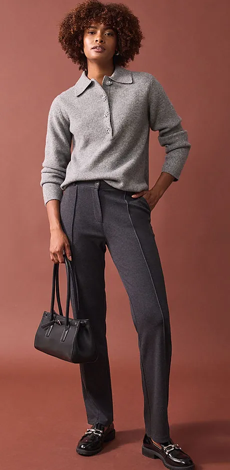 Stijlvolle grijze trui met elegante pantalon en zwarte loafers.