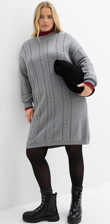Grijze gebreide jurk, zwarte panty en veterlaarsjes.