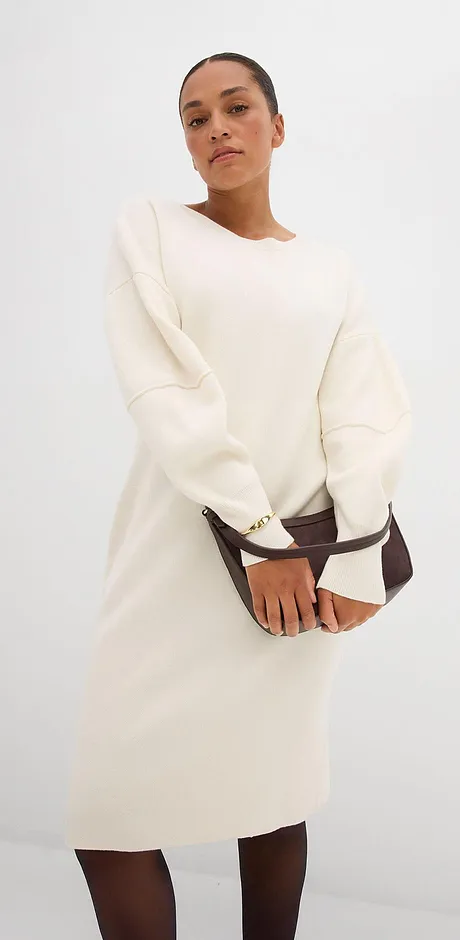 Crèmekleurige jurk met lange mouwen en ronde hals.