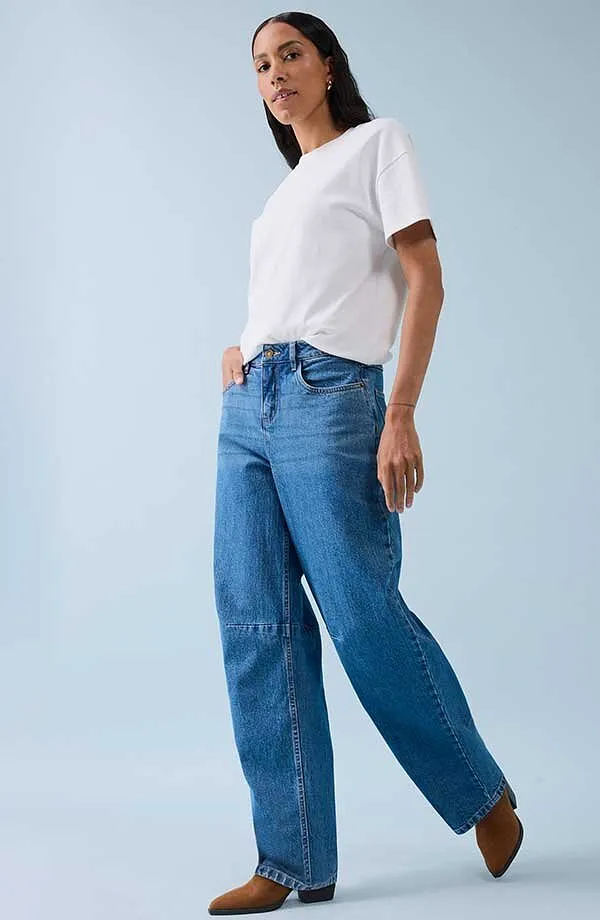 Klassiek wit T-shirt gecombineerd met wijde jeans en bruine schoenen.