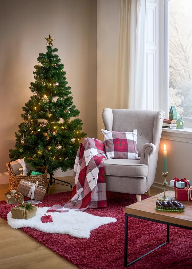 Kerstboom en fauteuil in woonkamer.