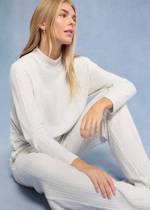 Elegante gebreide trui in wit met opstaande kraag, perfect gecombineerd met een bijpassende witte broek.