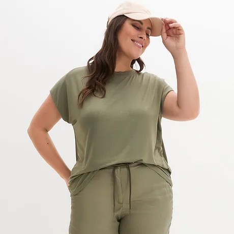 Olivgrünes T-Shirt und passende Hose, ergänzt durch eine beige Baseballkappe.