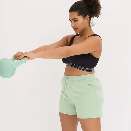 Zwarte sport top met band met logo, gecombineerd met een mintgroene short voor een frisse workout-look.