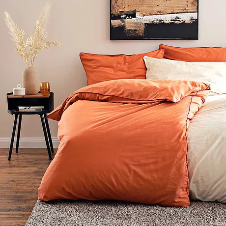 Comfortabel dekbedovertrek in warme tinten oranje en crème om heerlijk in weg te dromen.