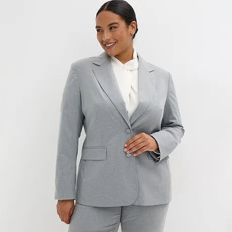 Grijze blazer met witte blouse.