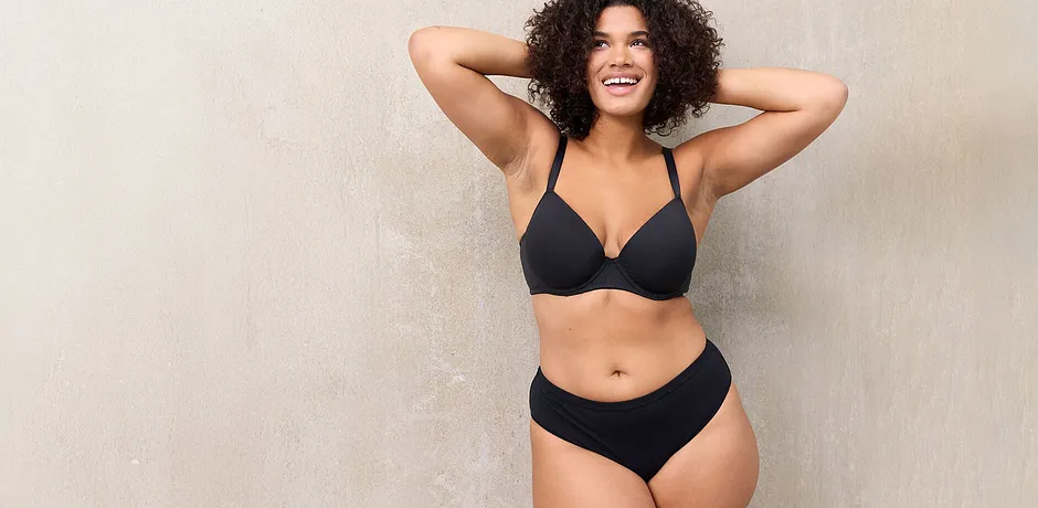 Zwarte lingerie benadrukt de natuurlijke schoonheid en rondingen van de zelfverzekerde vrouw.