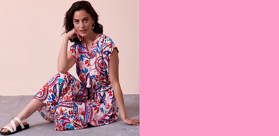 Kleurrijke, zomerse blousejurk met abstract patroon in rood, wit en blauw.