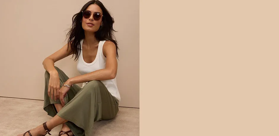 Witte tanktop, olijfgroene broek en bruine sandalen - samen met de zonnebril een relaxte zomerlook.