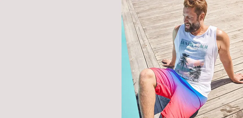 Witte tanktop en zwembroek in de kleuren pink en blauw, perfect voor bij het zwembad of aan het strand.