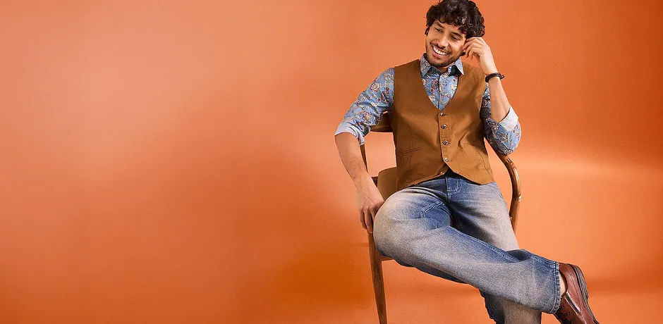 Stijlvolle combinatie met jeans, overhemd met print en bruin gilet.