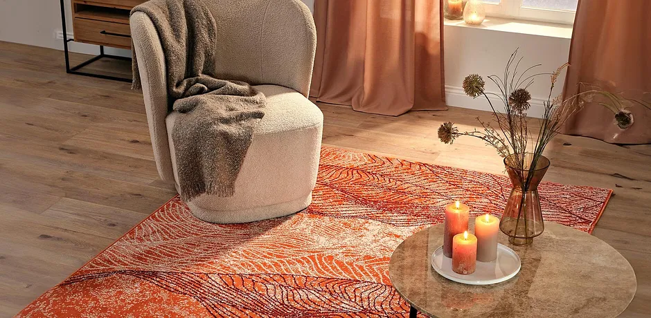 Een comfortabele fauteuil op een prachtig vloerkleed, De warme kleuren zorgen voor een behaaglijke sfeer.