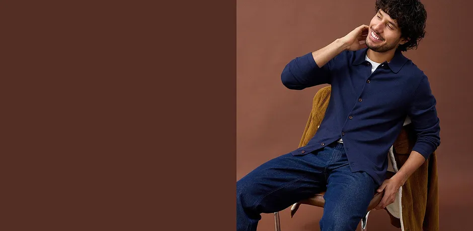 Blauw fijngebreid vest met merinowol gecombineerd met blauwe jeans.