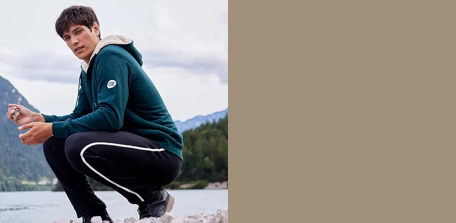 Groen sweatvest en zwarte joggingbroek voor buitenactiviteiten.