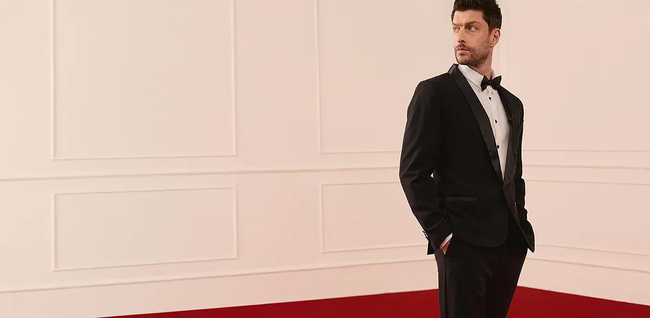 Elegante zwarte smoking met wit overhemd en vlinderdasje voor feestelijke gelegenheden.