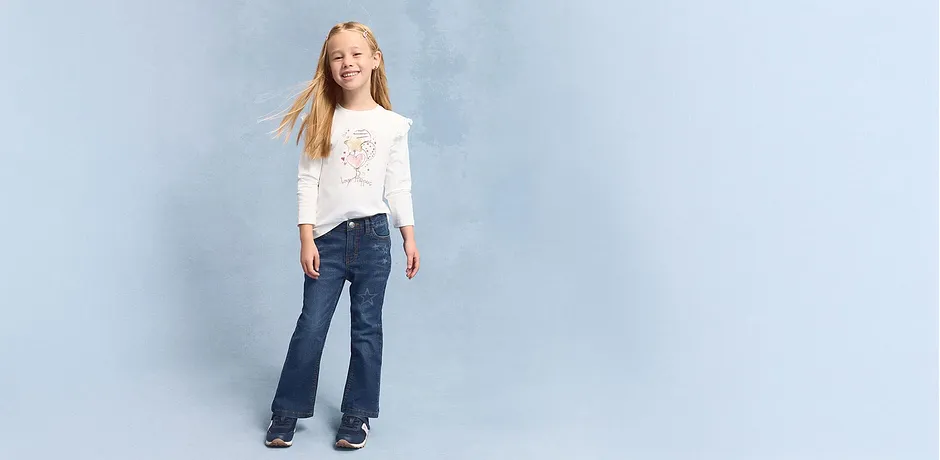 Casual look met witte longsleeve en jeans met uitlopende pijpen.