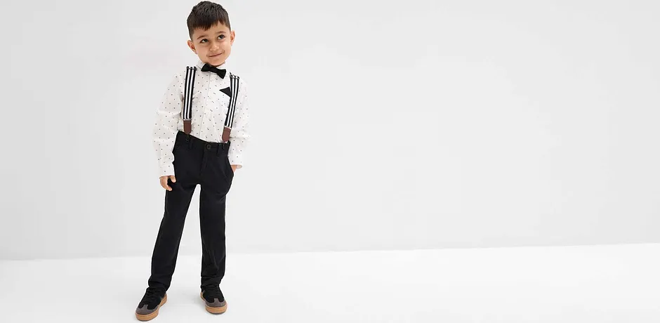 Jongen draagt overhemd en vlinderdasje.