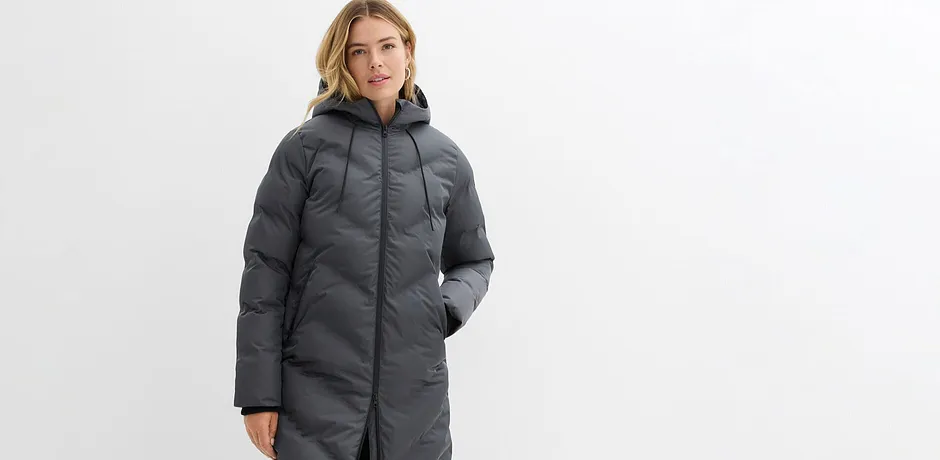 Lange grijze winterjas met capuchon en ritssluiting.