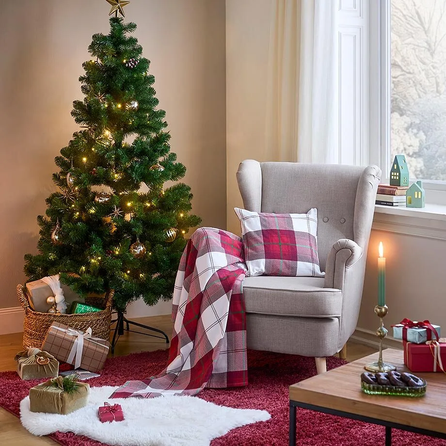 Kerstboom en fauteuil in woonkamer.