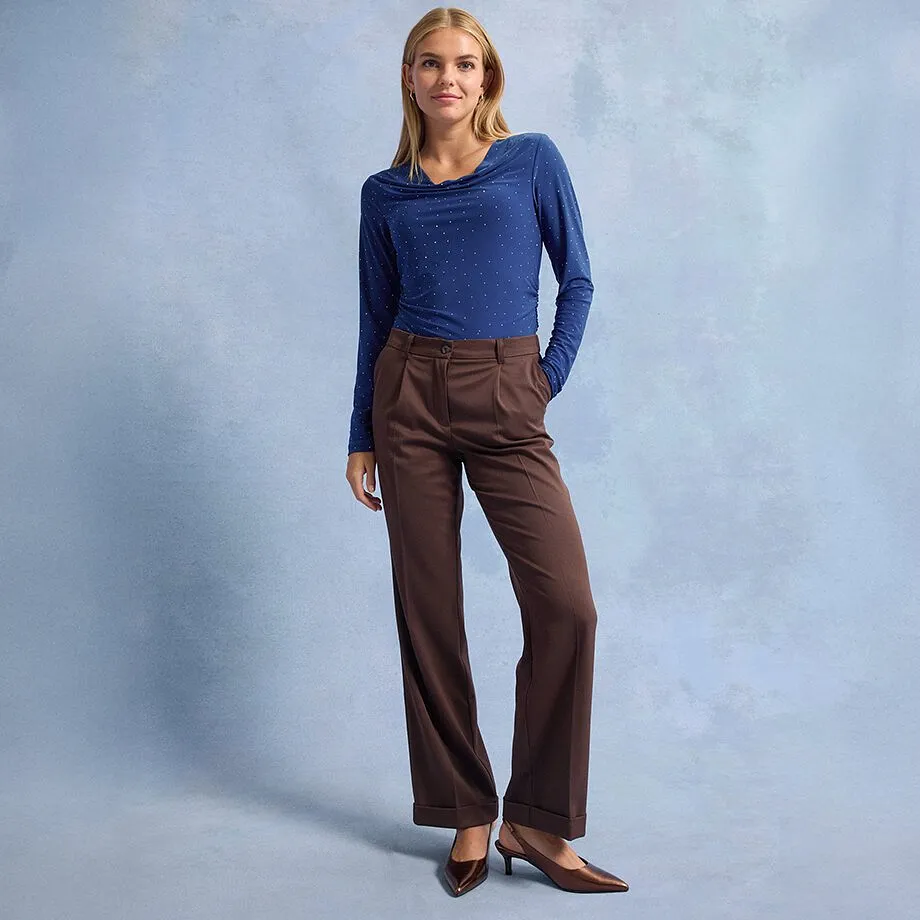 Blauwe longsleeve met stippen, bruine broek met wijde pijpen en bruine pumps met spitse neus.