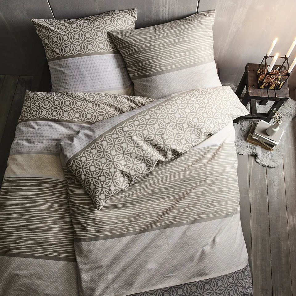 Dekbedovertrek in neutrale tinten met fijne motieven.