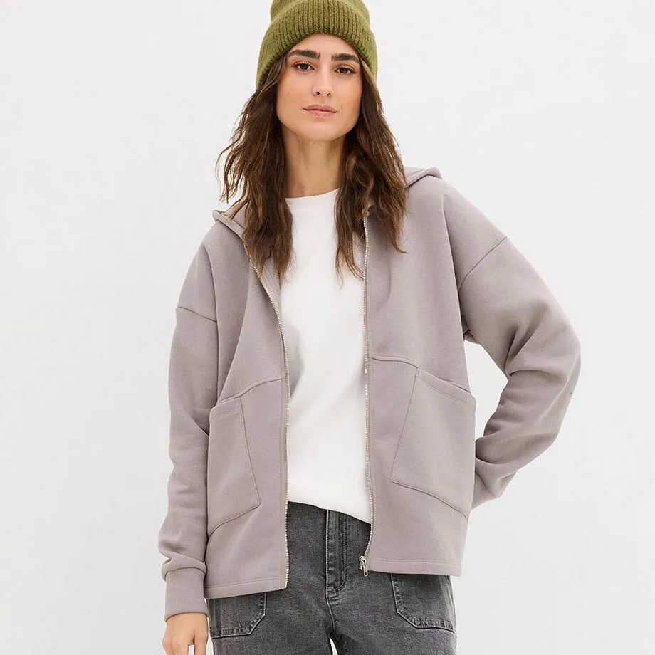 Wit shirt en grijs fleece vest over grijze jeans.