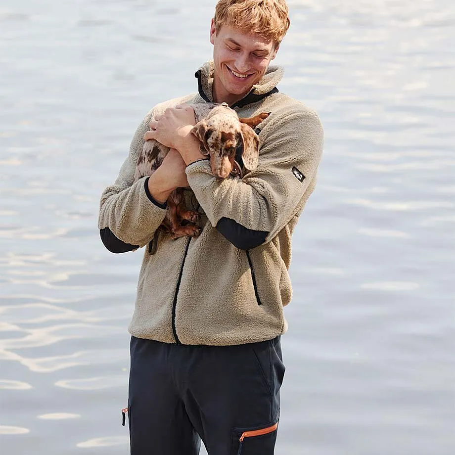 Beige fleece vest gecombineerd met donkere broek.