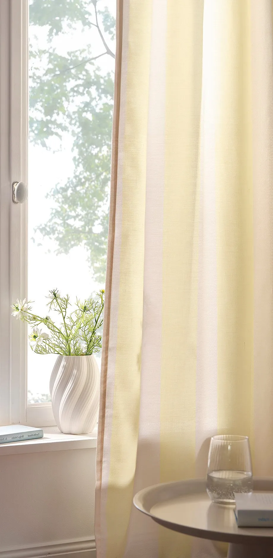 Geel gordijn voor het raam.