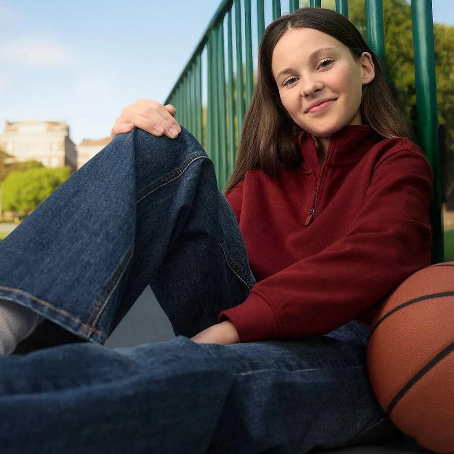 Casual look met rode trui en blauwe jeans.