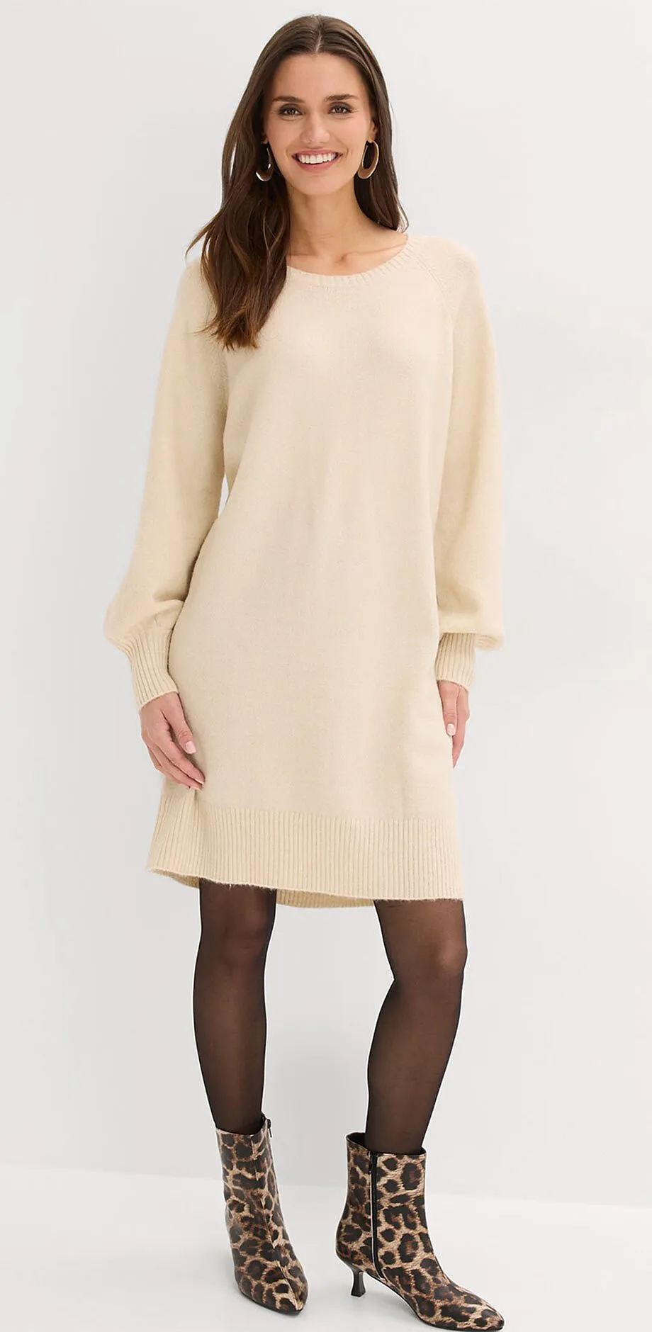 Cr&egrave;mekleurige gebreide jurk met lange mouwen.